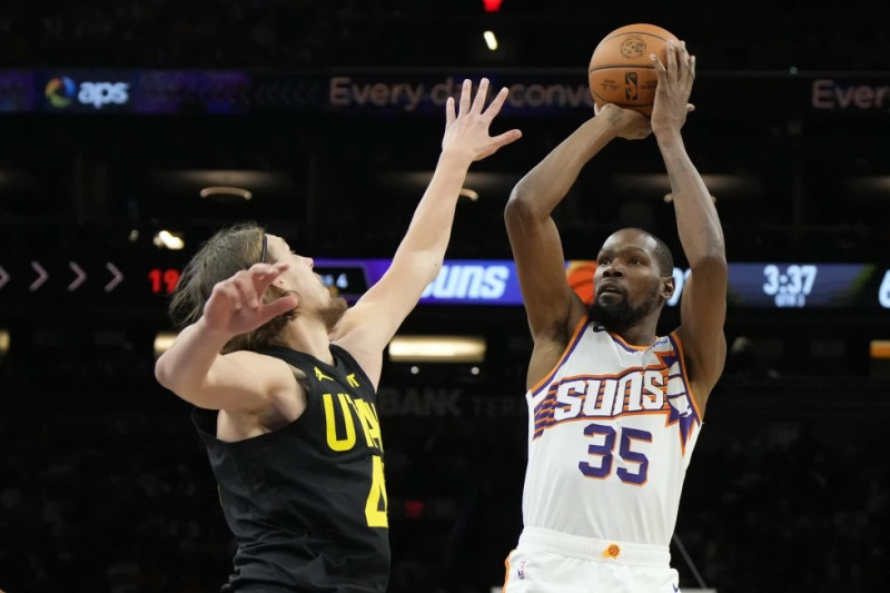 Kevin Durant, alero de los Suns de Phoenix, dispara frente a Kelly Olynyk, del Jazz de Utah.