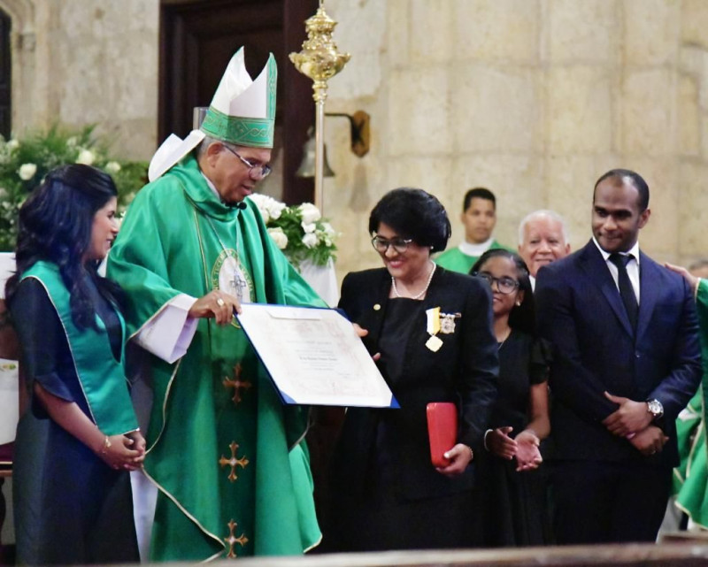 El arzobispo Francisco Ozoria entrega reconocimiento a la magistrada Eunisis Vásquez.