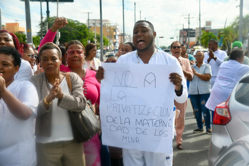 Un enfermero de la Maternidad de Los Mina protesta con una cartulina en contra de la presunta privatizacion del centro medico.