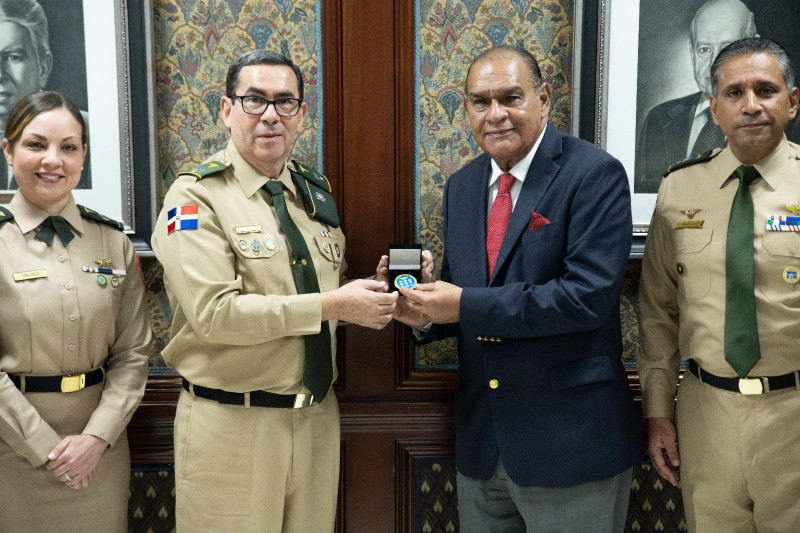 El general de brigada médico Luis Díaz Morfa entrega una medalla de las Fuerzas Armadas al director del Listín Diario, Miguel Franjul.