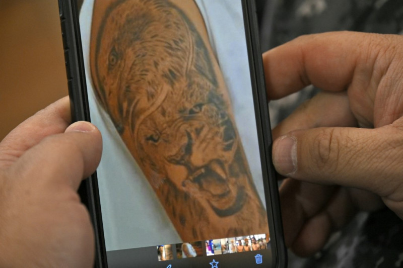 El jefe de la unidad policial Nueva Properina, en Guayaquil, muestra imágenes de tatuajes encontrados en teléfonos móviles incautados en operativos policiales