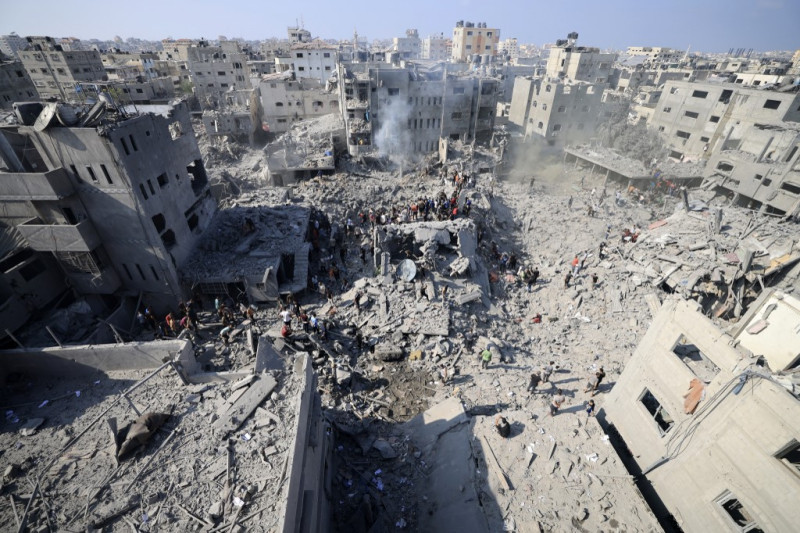 La gente revisa los escombros de los edificios destruidos en un ataque israelí contra el campo de refugiados de Bureij en el centro de la Franja de Gaza el 2 de noviembre de 2023, mientras continúan las batallas entre Israel y el movimiento palestino Hamás.