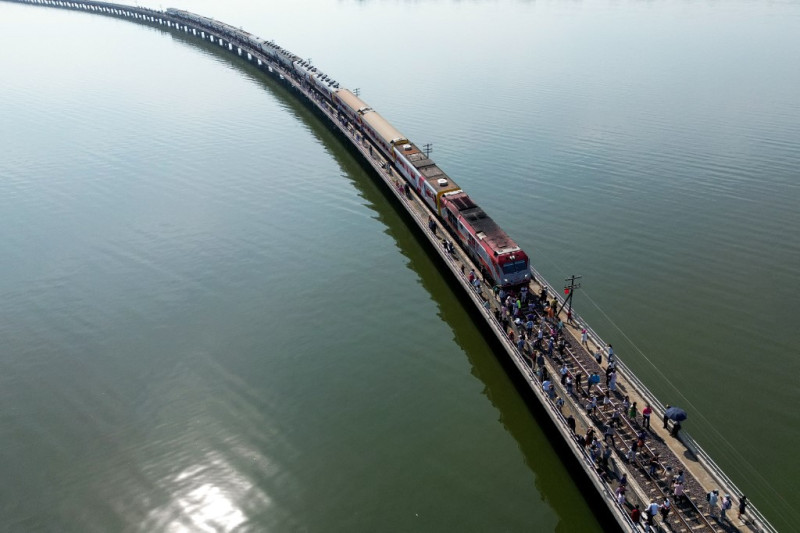 Esta fotografía aérea muestra a turistas que viajan a bordo del popular "tren flotante a lo largo de las vías del tren durante una parada en medio de la presa de Pasak Jolasid, el mayor embalse de Tailandia, en la provincia de Lopburi