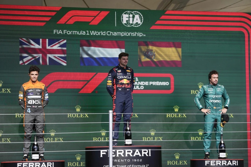 El piloto de Red Bull Max Verstappen en lo alto del podio junto a Landor Norris de McLaren y Fernando Alonso de Aston Martin tras el Gran Premio de Brasil en Interlagos.
