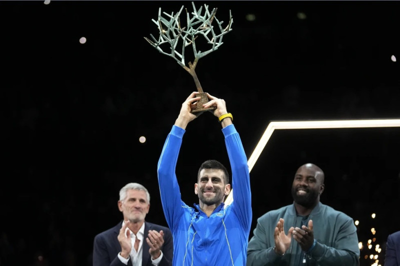 El serbio Novak Djokovic sostiene el trofeo de campeón tras ganar la final del Masters de París al superar al búlgaro Grigor Dimitrov.