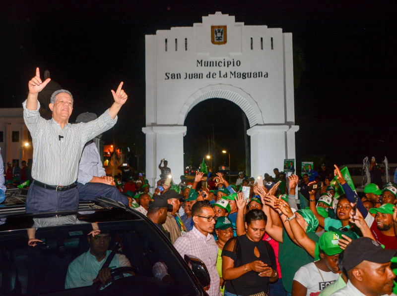 Leonel Fernández saluda a la multitud que lo vitoreó a su paso ayer por San Juan.