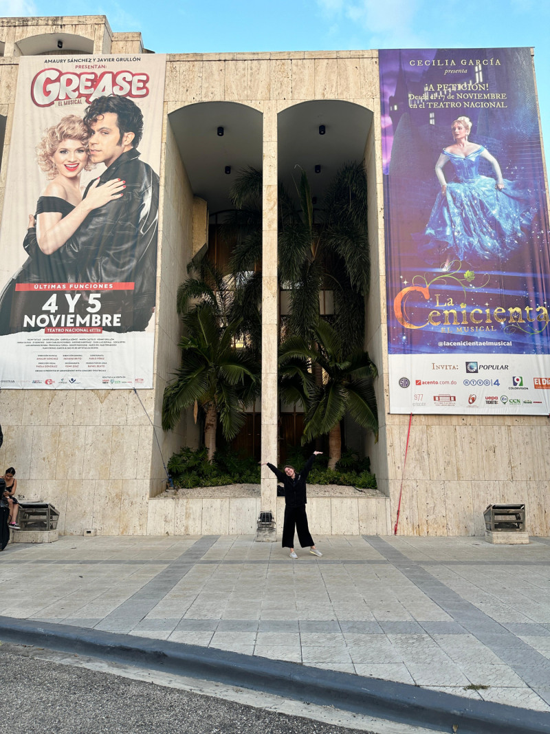 Gabriela Gómez junto a los carteles gigantes colgados en el Teatro Nacional donde se anuncian los musicales que ella protagoniza.