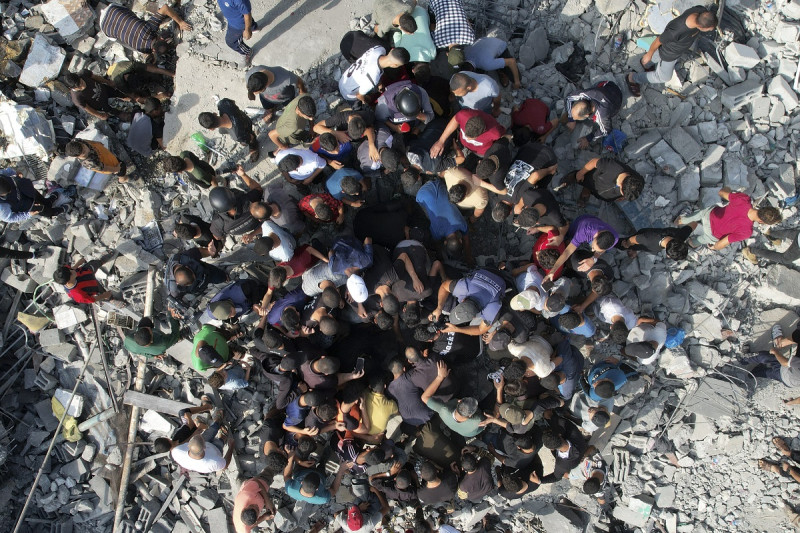 Palestinos buscan sobrevivientes entre los escombros que dejó un bombardeo israelí, el domingo 5 de noviembre de 2023, en el campamento de refugiados Maghazi, en la Franja de Gaza. (AP Foto/Hatem Moussa)