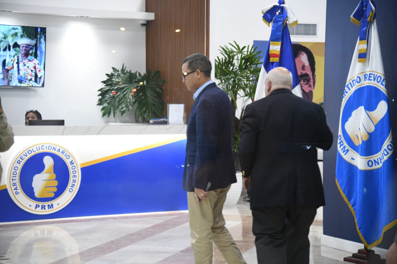 Eddy Olivares, vicepresidente del PRM y Juarez Castillo, de la FNP, conversan esta noche en la casa nacional del partido oficialista