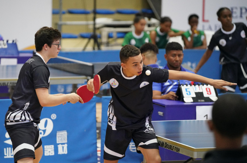 Un momento de acción del torneo de tenis de mesa de los Juegos Escolares en la modalidad dobles masculinos.