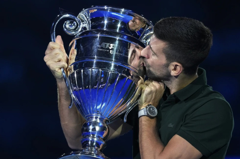 El serbio Novak Djokovic besa el trofeo como el mejor jugador de la ATP durante las Finales de la ATP en Turín, Italia.