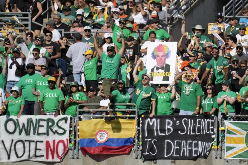 Foto del 5 de agosto del 2023, aficionados de los Atléticos de Oakland gritan y colocan pancartas pidiéndole al dueño que venda al equipo y lo mantenga en Oakland durante el encuentro ante los Gigantes de San Francisco.