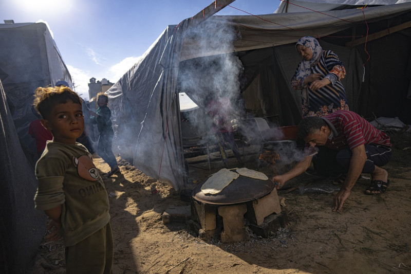 Palestinos desplazados por los bombardeos israelíes en la Franja de Gaza preparan pan en un campamento montado por el Programa de la ONU para el Desarrollo, el miércoles 15 de noviembre de 2023, en Jan Yunis, Franja de Gaza.