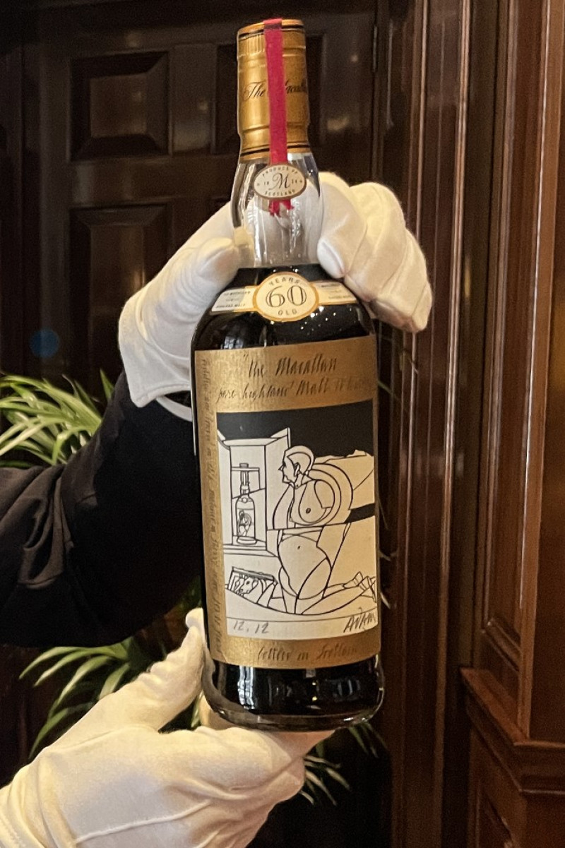 Un miembro del personal muestra una botella de The Macallan Valerio Adami 60 Year Old 42.8 abv 1926, el whisky más valioso del mundo