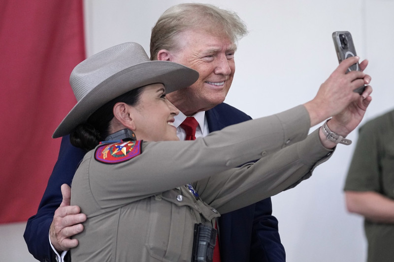 Donald Trump posa con un policía de Texas mientras ayuda a servir comida a los soldados, policías y otras personas de la Guardia Nacional, ayer.