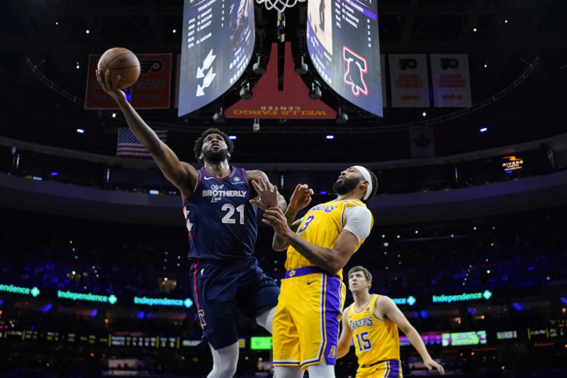 Joel Embiid, de los Sixers, se eleva en busca de un canasto frente a Anthony Davis, de los Lakers de Los Angeles.
