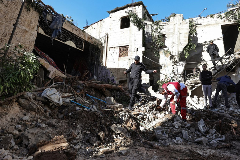 Un rescatista y residentes comprueban los daños de una casa tras una incursión israelí en la ciudad ocupada de Yenín, en Cisjordania, el 29 de noviembre de 2023