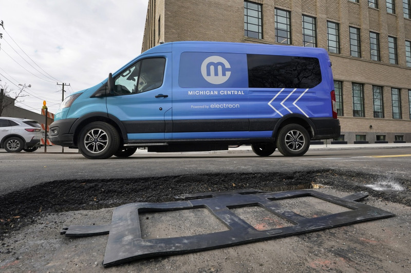 Una camioneta eléctrica pasa ayer miércoles frente a una bobina de cobre de carga inalámbrica que será instalada en una calle de Detroit.