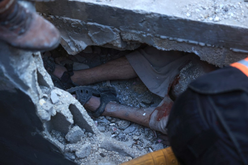 Médicos palestinos intentan rescatar a un hombre de entre los escombros de un edificio que se derrumbó tras un bombardeo israelí en el sur de la Franja de Gaza, el 1 de diciembre de 2023