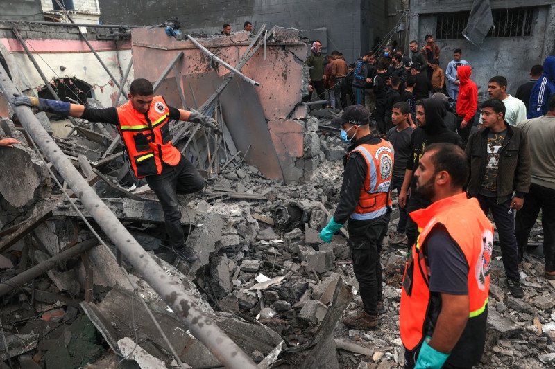 Médicos palestinos buscan supervivientes entre los escombros de un edificio tras un bombardeo israelí en Rafah, en el sur de la Franja de Gaza, el 1 de diciembre de 2023