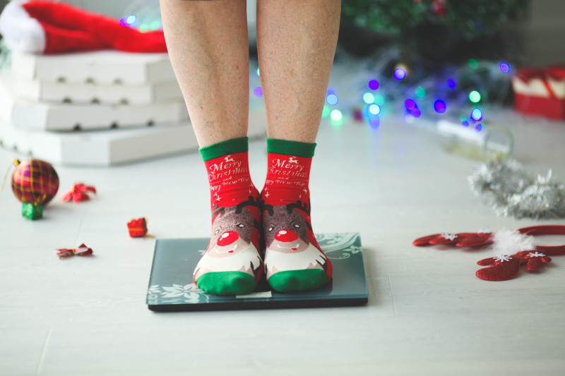 Mujer con calcetines navideños sobre una báscula doméstica. Foto: IMEO.