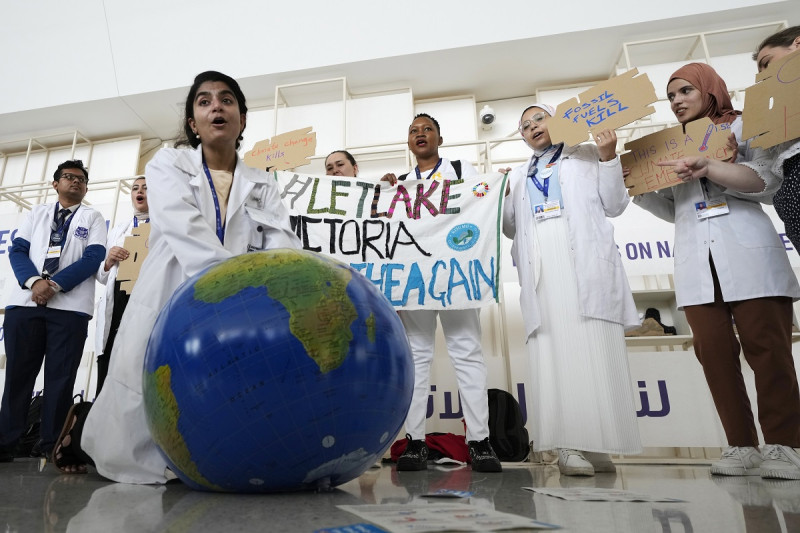 Una mujer simula reanimar al planeta Tierra durante una manifestación en la conferencia climática COP28, ayer en Dubái, Emiratos Árabes Unidos.
