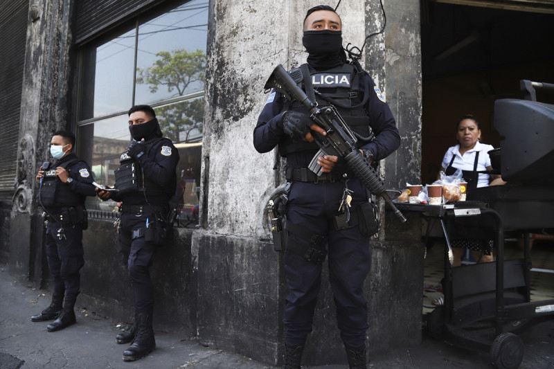 Agentes de la policía fuertemente armados custodian las calles después de que el Congreso de El Salvador acogiera el pedido del presidente Nayib Bukele de declarar el estado de excepción en marzo de 2022.