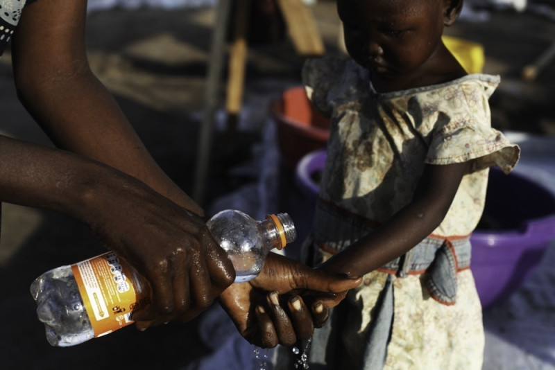 Una madre lava las manos a su hija para evitar el cólera en Sudán del Sur.