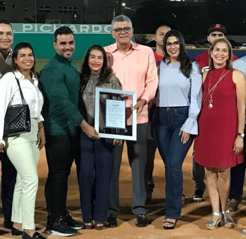 Rafael Villalona recibe el reconocimiento rodeado de la familia.