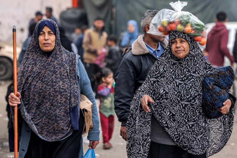 Mujeres caminan por una calle en Rafah, en el sur de la Franja de Gaza, el 12 de diciembre de 2023, en medio de continuas batallas entre Israel y el grupo militante Hamás.