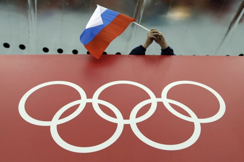 Foto del 14 de febrero del 2014, la bandera rusa es ondeada sobre los anillos olímpicos en Adler Arena Skating Center durante los Juegos Olímpicos de Invierno en Sochi, Rusia.