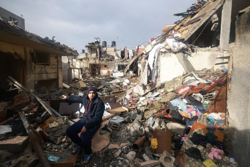 Un palestino inspecciona los daños entre los escombros tras los bombardeos israelíes en Rafah, en el sur de la Franja de Gaza, el 13 de diciembre de 2023, mientras continúan los combates entre Israel y Hamás