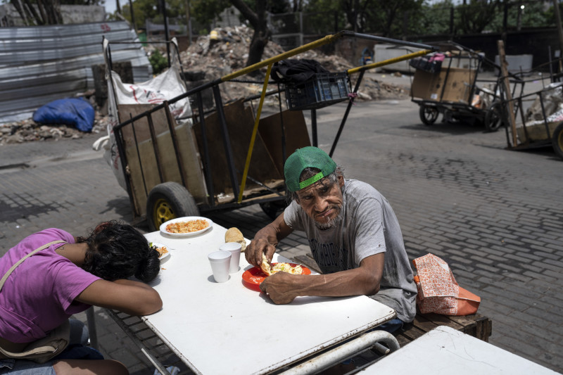 Dos personas almuerzan una comida gratuita del comedor social de la Casa Comunitaria del Fondo, en el barrio Padre Carlos Múgica de Buenos Aires, el jueves pasado.