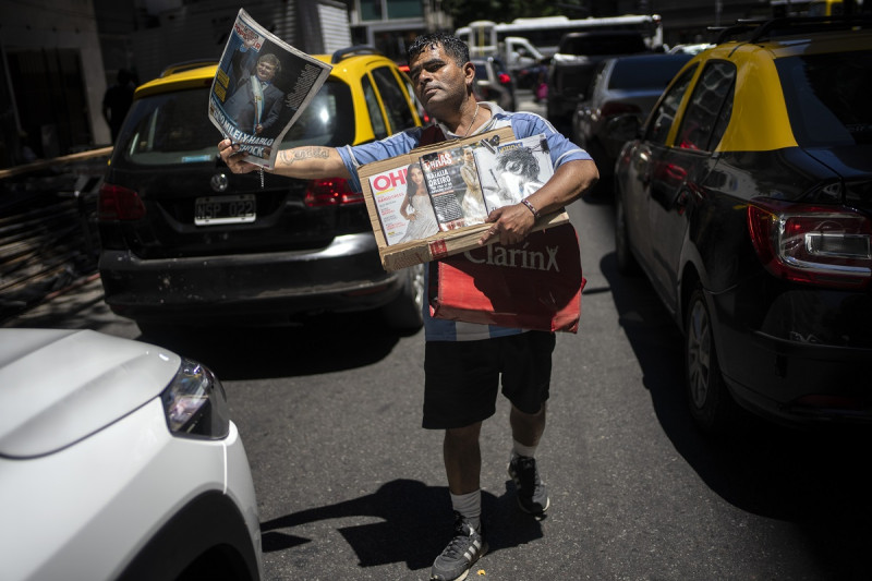 Un vendedor callejero ofrece periódicos con noticias sobre el inicio del gobierno del presidente de Argentina, Javier Milei, en Buenos Aires, el 11 de diciembre de 2023.