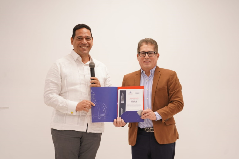 Elmer González entrega el reconocimiento a Iván Ruiz, director de RTVD.