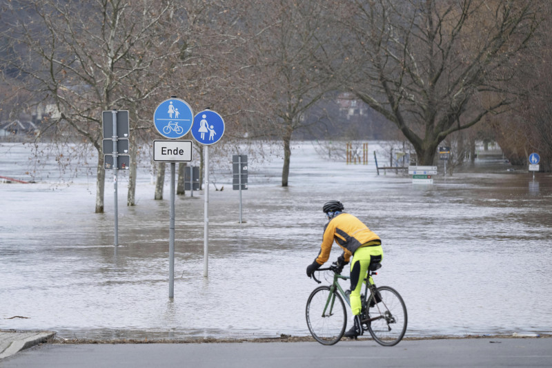 Un ciclista pasa por un camino junto a una zona inundada cerca del río Elba, en Pirna, Alemania, el jueves 28 de diciembre de 2023.