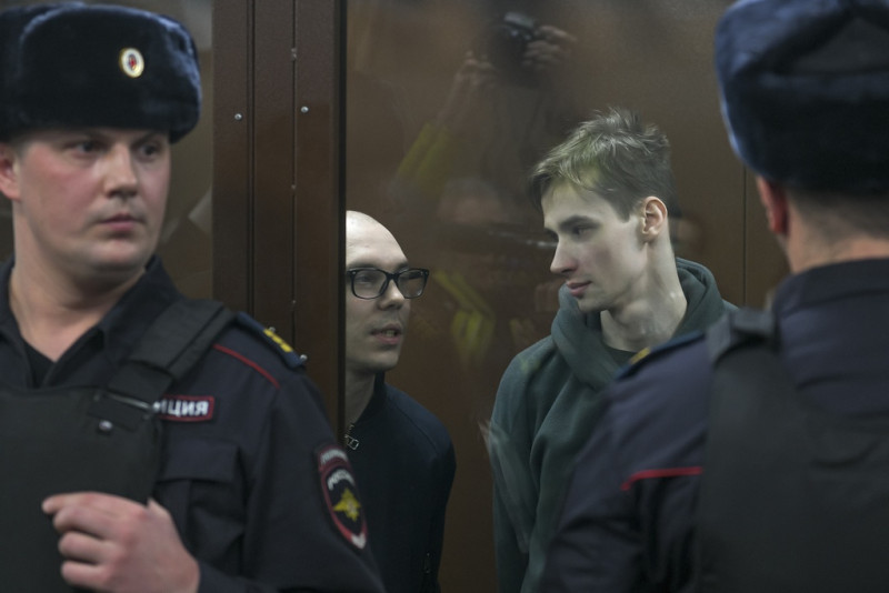 Artyom Kamardin (izquierda) y Yegor Shtovba (derecha), detrás del cristal de la zona de acusados en un tribunal en Moscú, Rusia, el 28 de diciembre de 2023
