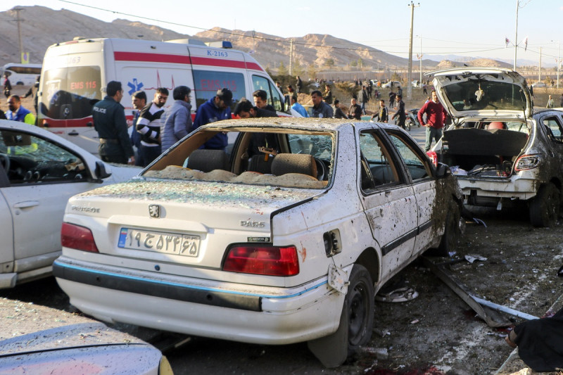 Varias personas junto a automóviles destrozados luego de unas explosiones en Kermán, Irán, el miércoles 3 de enero de 2024.