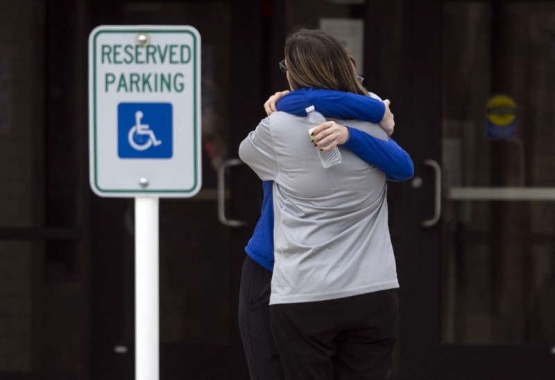 Dos personas se abrazan en un centro de reunificación en el McCreary Community Building después de un tiroteo en el complejo Perry Middle and High School en Perry, Iowa, el 4 de enero de 2024.