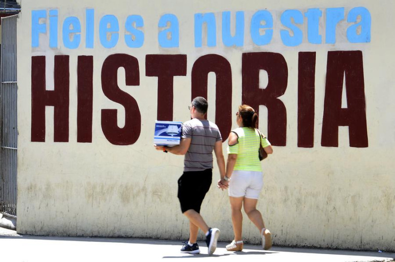 Personas caminan frente a una pared pintada en el centro de La Habana, capital de Cuba, el 5 de mayo de 2019. Políticos, funcionarios y académicos cubanos han reaccionado con enérgico rechazo a la activación total por parte de Estados Unidos de la Ley Helms-Burton, que desde 1996 codifica el entramado legal del bloqueo impuesto a la isla hace más de medio siglo por la Casa Blanca. (Xinhua/Joaquín Hernández)