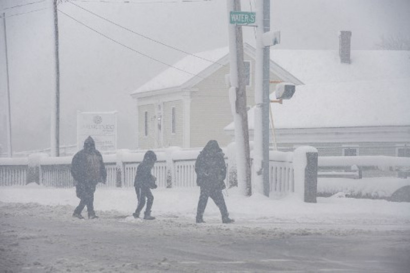 La gente camina a través de la tormenta de nieve en Lawrence, Massachusetts, el 7 de enero de 2024. Los meteorólogos advirtieron el 5 de enero que un diluvio de nieve y las condiciones invernales podrían provocar un caos en los viajes al noreste de EE. UU. este fin de semana, con unos 25 millones de personas sujetas a una advertencia de tormenta.