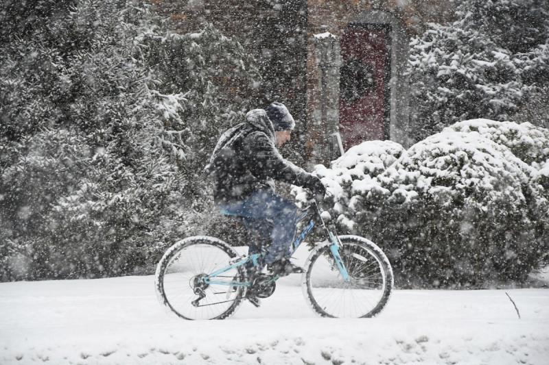 Un ciclista pasa sobre la acera de un camino en North Adams, Massachusetts, el domingo 7 de enero de 2024 durante una tormenta invernal.