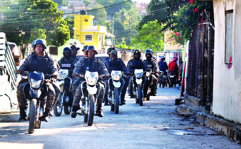 Patrullas montadas de la Policía Nacional se desplazan a través de una calle del sector Los Guandules.