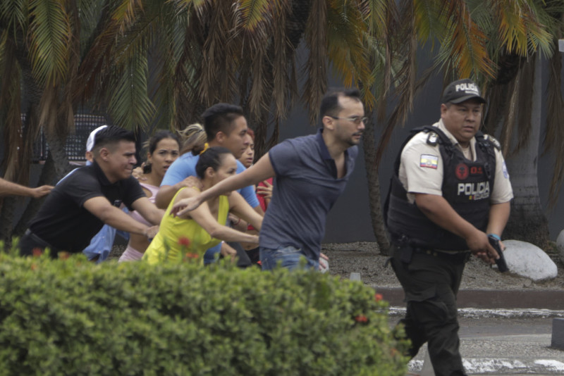 La policía evacúa a personal del canal TC Televisión después de que un grupo armado y encapuchado irrumpiera en plena transmisión en directo, en Guayaquil, Ecuador, el martes 9 de enero de 2024.
