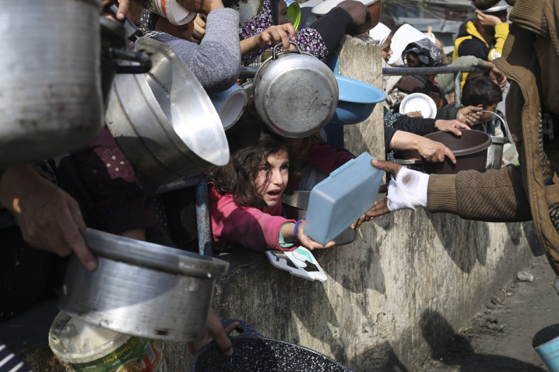 Palestinos hacen fila para conseguir comida durante la ofensiva aérea y terrestre en la Franja de Gaza, en Rafah, el martes 9 de enero de 2024.