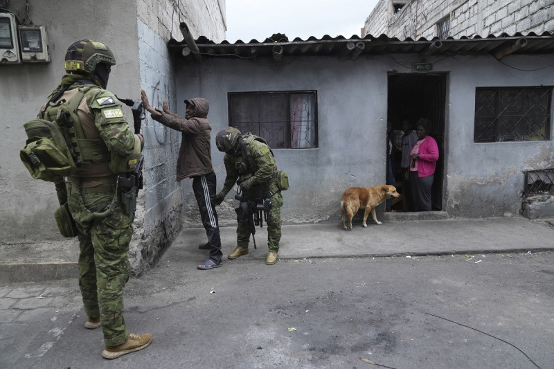 Soldados detienen y registran a un peatón en busca de armas mientras patrullan zonas residenciales en el norte de Quito, antier.