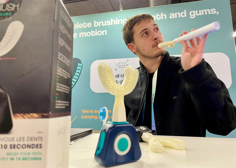Jad Sassine from Hydro-One, demonstrate how to use the Y-Brush, an electric toothbrush supposed to clean the teeth in only 20 seconds total, during the Consumer Electronics Show (CES) in Las Vegas, Nevada, on January 11, 2024. (Photo by Julie JAMMOT / AFP)