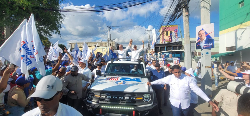 El presidente Luis Abinader saluda a seguidores al paso de su caravana en Santiago.