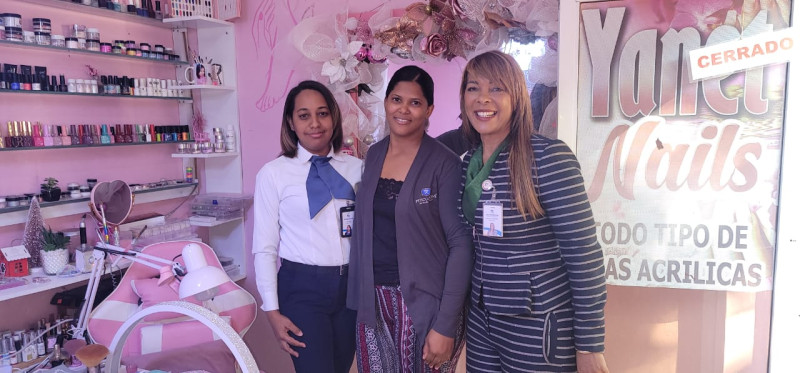 La gerente de oficina de Banreservas en Pedernales, Rudylaina Salomón y la oficial de Negocios Melcy Báez visitaron a Yanet en su local.