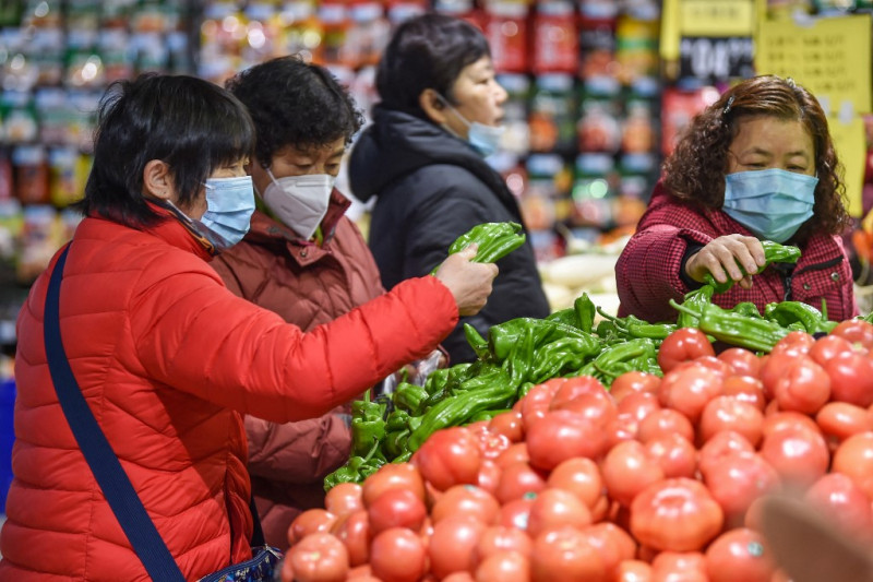 Un grupo de personas compra frutas y verduras en un supermercado de Nanjing, en la provincia oriental china de Jiangsu, el 12 de enero de 2024.